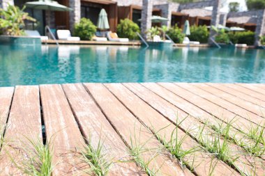 Tatil köyünde ahşap güverteli açık havuz.