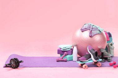 Pembe arka planda birçok farklı spor ekipmanı, metin için boşluk