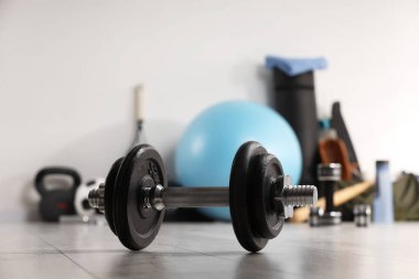 Dumbbell ve diğer spor ekipmanları kapalı alanda, yakın plan.