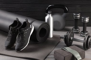 Gri ahşap masada birçok farklı spor ekipmanı var.