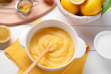 Lezzetli limon kaymağı, malzemeler, kaşık ve elek beyaz ahşap masa, düz yatıyordu