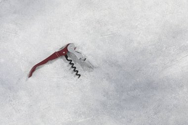 Gri desenli masa üzerinde bir tirbuşon (sommelier bıçak), üst manzara. Metin için boşluk