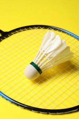 Tüylü badminton mekik siki ve raketi sarı arka planda