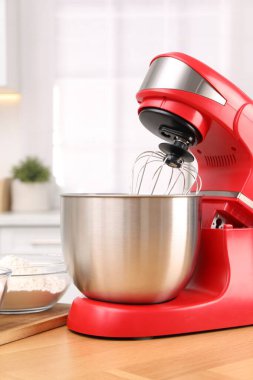 Mutfaktaki ahşap masada modern kırmızı stand mikseri.