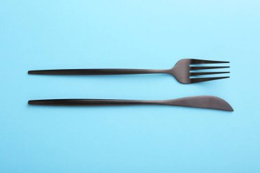 Açık mavi masadaki şık çatal bıçak takımı, üst görünüm