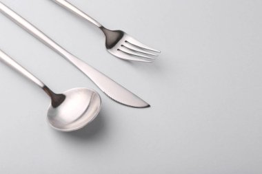 Gri masadaki şık çatal bıçak seti, yakın plan. Metin için boşluk