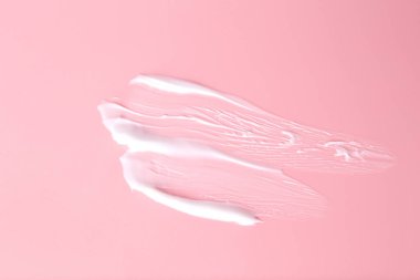 Pembe arka planda vücut bakım kremi örneği, üst görünüm.