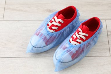 Açık ahşap zeminde mavi ayakkabılı spor ayakkabılar.