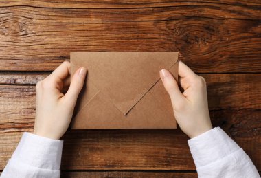 Tahta masadaki mektup zarflı kadın, üst manzara.