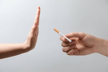 Gri arka planda sigara içmeyi reddeden adam, yakın plan.