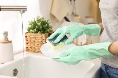 Mutfak lavabosunda bulaşık yıkayan kadın, yakın çekim. Temizlik işleri