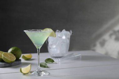 Lezzetli Margarita kokteyli ve beyaz ahşap masada limon, yazı için yer.