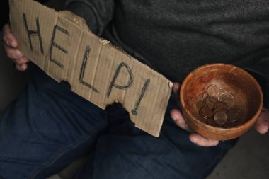 Elinde bağış kasesi tutan zavallı evsiz adam, yakın plan.
