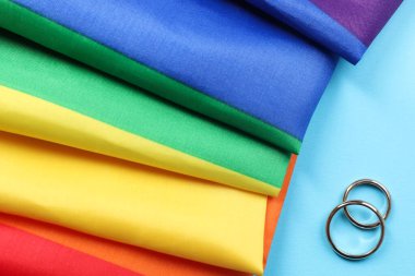 Gökkuşağı LGBT bayrağı ve açık mavi arka planda alyanslar, üst manzara