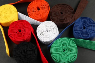 Gri arkaplanda renkli karate kemerleri, üst görünümde