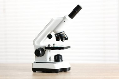 Kapalı alandaki ahşap masada modern tıbbi mikroskop.