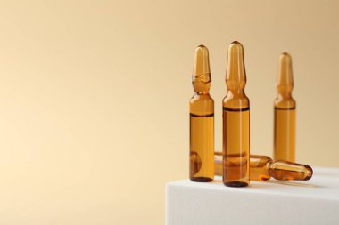 Bej arka planda sıvı olan cam ampuller. Metin için boşluk