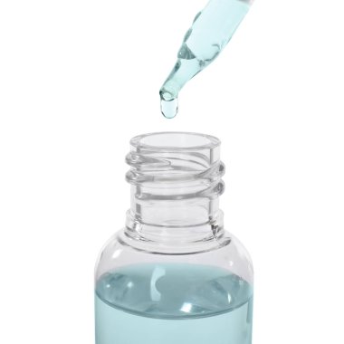 Beyaz arka planda şişeye damlayan tıbbi damlalar