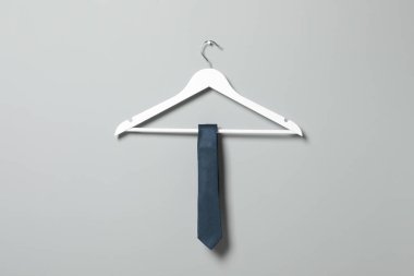 Açık gri duvarda mavi kravatlı askı