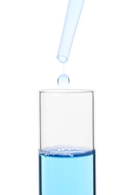 Pipetten test tüpüne sıvı damlıyor. Beyaz, yakın plan.