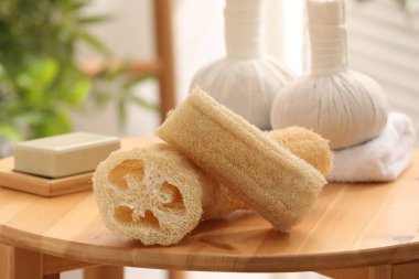 Loofah sponges on wooden table indoors, closeup clipart