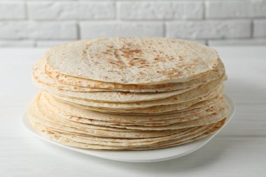 Beyaz ahşap masada ev yapımı lezzetli tortilla yığını.