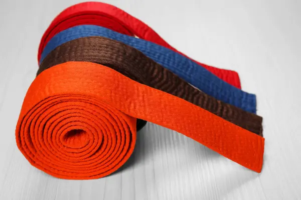 stock image Colorful karate belts on wooden background, closeup