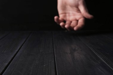 Siyah ahşap masanın üzerinde el ele tutuşan adam, seçici bir odak noktası. Metin için boşluk