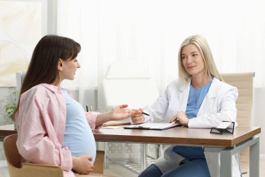 Doktor, klinikteki hamile hastaya danışıyor.