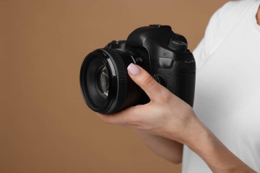 Kahverengi arka planda kamerası olan fotoğrafçı, yakın plan. Metin için boşluk