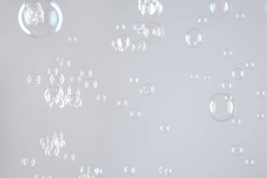 Açık gri arkaplanda güzel şeffaf sabun köpükleri