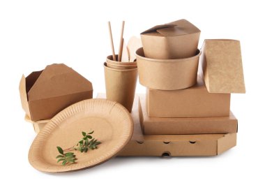 Çevre dostu yiyecek paketleri, sofra takımı ve ince dallar beyaz üzerine izole edilmiş.