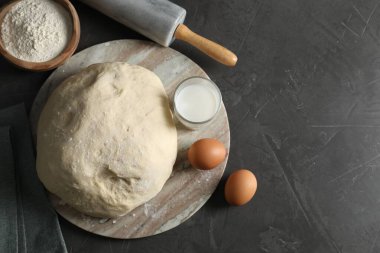 Çiğ hamur, merdane ve malzemeler siyah masada, üst manzara. Metin için boşluk