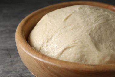 Gri masadaki kasede çiğ hamur, yakın plan.