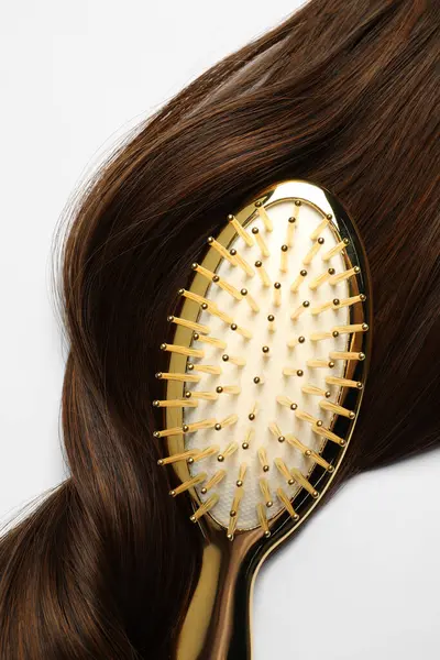 Beyaz zemin üzerinde kahverengi saç teli olan şık fırça, üst görünüm