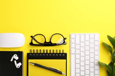 Sarı arkaplan üzerine ofis kırtasiyesi ile düz kompozisyon, metin için boşluk