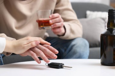 Sarhoş bir adamın araba anahtarlarını almasını engelleyen bir kadın. İçkili araba kullanma.