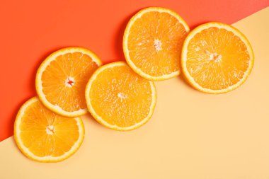 Renkli arka planda sulu portakal dilimleri, üst görünüm