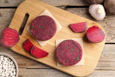 Vejetaryen ürünü. Pişmemiş pancar pirzolası ve ahşap masa üzerindeki malzemeler.