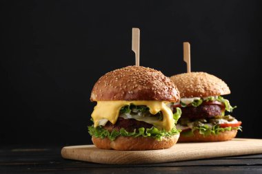 Siyah ahşap masada lezzetli köfteli vejetaryen hamburgerler.