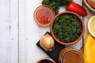 Farklı taze salamuralar ve beyaz ahşap masa üzerindeki malzemeler. Metin için boşluk