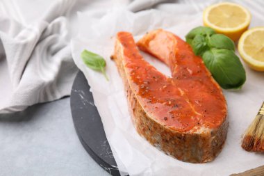 Taze salamura, balık, limon ve fesleğen gri masada, yakın plan.