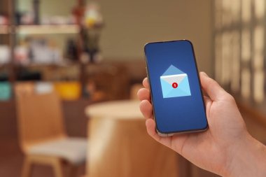 Cafe 'de cep telefonundan bir mesaj gelmiş. Aygıt ekranında zarf illüstrasyonu