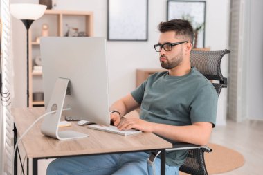 Ofisteki masada bilgisayarla çalışan programcı