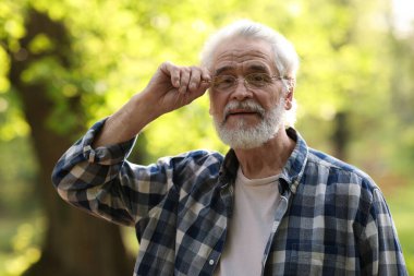 Parkta gözlüklü mutlu büyükbabanın portresi.