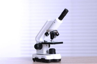 Kapalı alandaki ahşap masada modern tıbbi mikroskop.