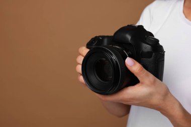 Kahverengi arka planda kamerası olan fotoğrafçı, yakın plan. Metin için boşluk