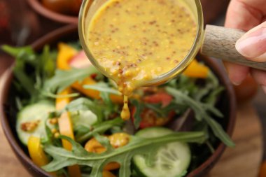 Lezzetli sirke sosu (Vinaigrette) masaya salatayla dolduran kadın, yakın plan.