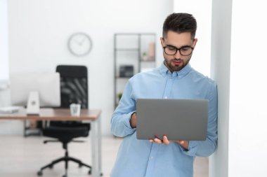 Genç programcı ofiste dizüstü bilgisayar ile çalışma