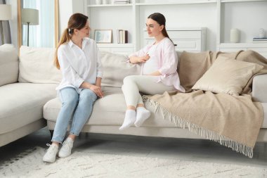 Doula evdeki kanepede hamile bir kadınla çalışıyor. Çocuk doğumu hazırlığı